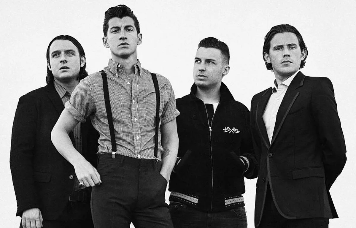 Arctic Monkeys sur scène, éclairage bleu et rouge, public en liesse, concert 2025