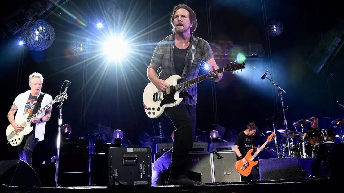 Pearl Jam sur scène, éclairage bleu et violet, public visible au premier plan