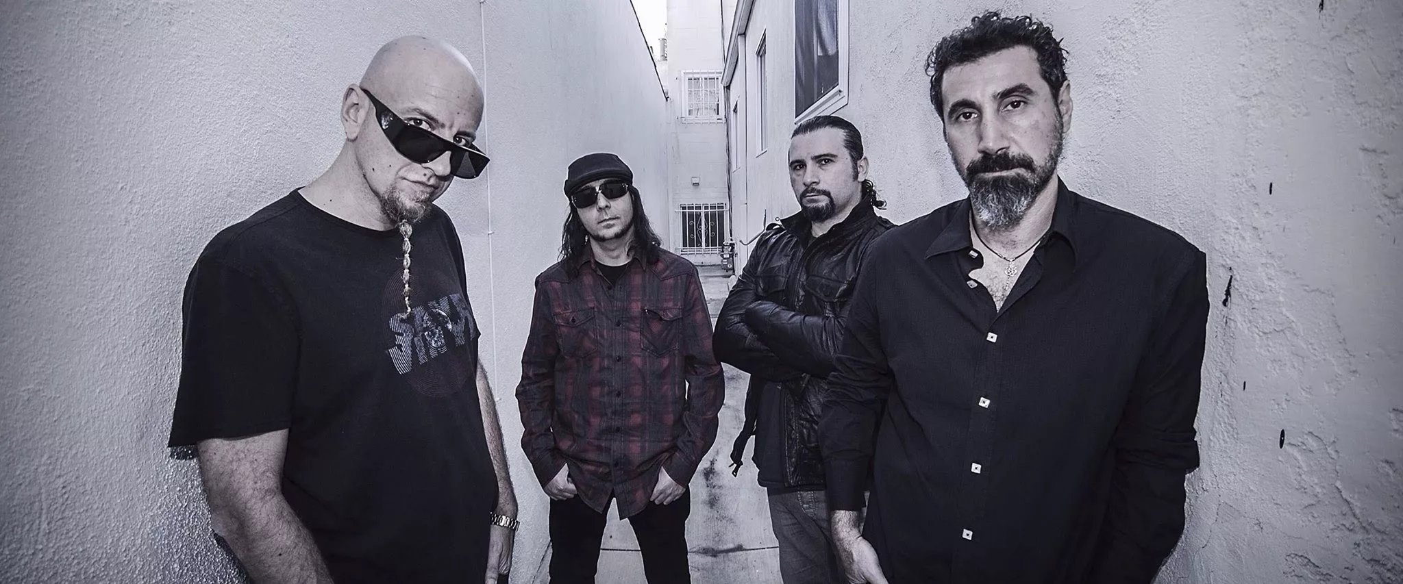 System of a Down : histoire, membres et albums d'un groupe inclassable Les quatre membres de System of a Down posant ensemble sur scène, éclairage de concert