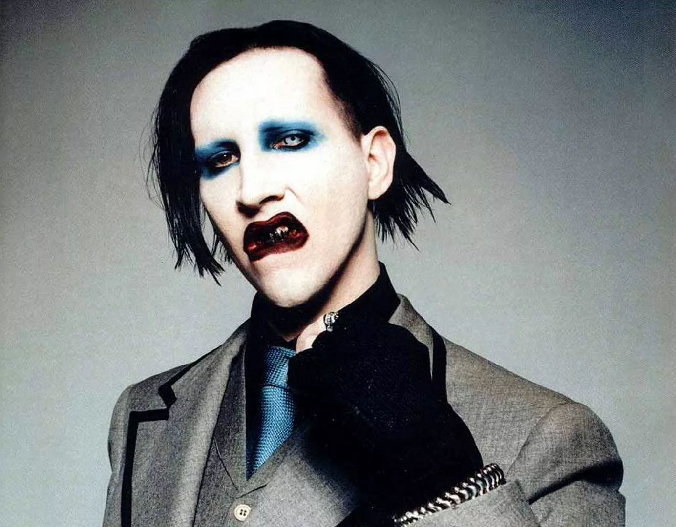 Marilyn Manson : biographie, albums et controverses d'une icône du choc Marilyn Manson sur scène, maquillage blanc, ambiance sombre, lumière bleutée, expression intense
