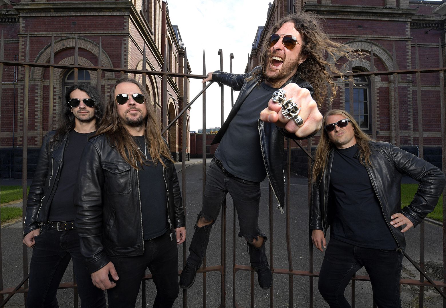 Joel O'Keeffe d'Airbourne debout sur les retours de scène, guitare levée, foule enthousiaste en festival