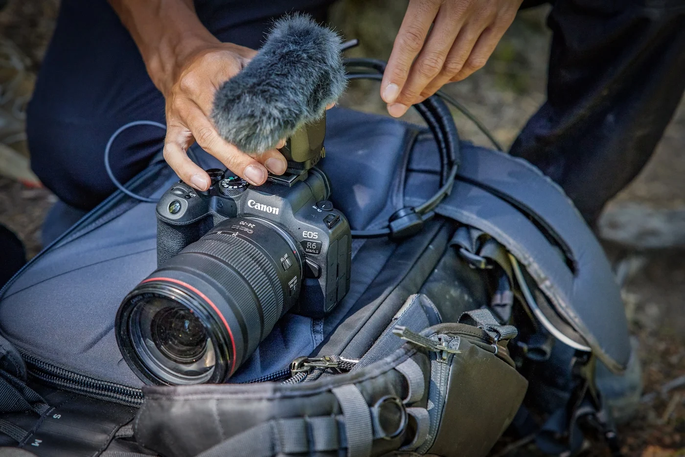 Photographe en action avec Canon EOS R6 Mark II dans un salon faiblement éclairé, gestion lumière ambiante pour photo d'intérieur