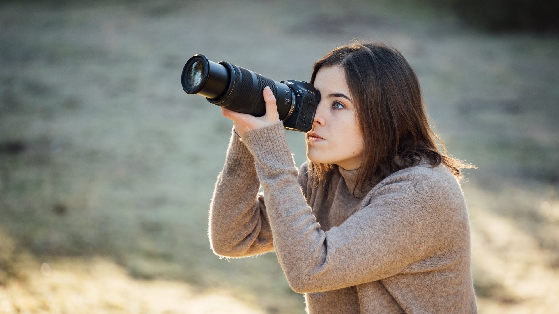 Canon R7 : test et avis d'un pro en concert Canon R7 avec objectif RF 18-150mm, vue de dessus, écran orientable déployé