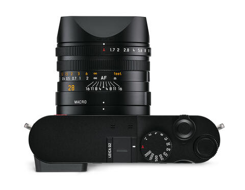 Leica Q2 : test et avis pour la photo de concert Leica Q2 entre les mains d'un photographe, scène de concert en arrière-plan