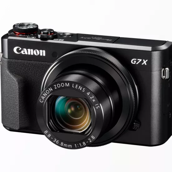 Canon G7X : avis d'un pro pour le concert et le voyage Canon G7X dans la main, prêt à déclencher, environnement urbain en fond