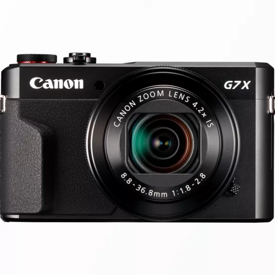 Canon G7X : avis d'un pro pour le concert et le voyage Canon G7X posé à côté d’un smartphone pour comparaison de taille