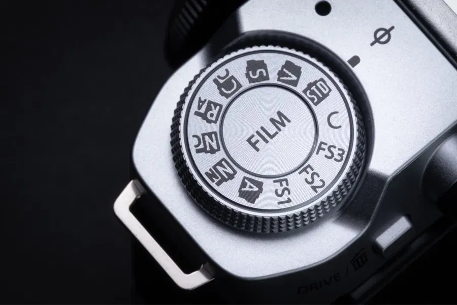 Fujifilm X-M5 en main, écran orientable visible, prise en main illustrée par un photographe