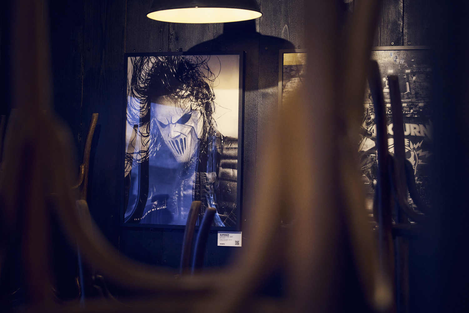 Tirage photo encadré d'un portrait de scène, vu à travers les verres suspendus au-dessus du bar de La Distillerie