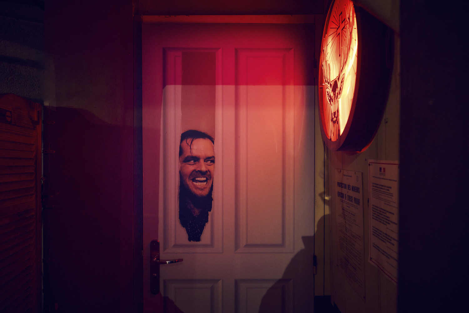 Porte d'entrée de La Distillerie éclairée en rouge, bar rock à Montpellier