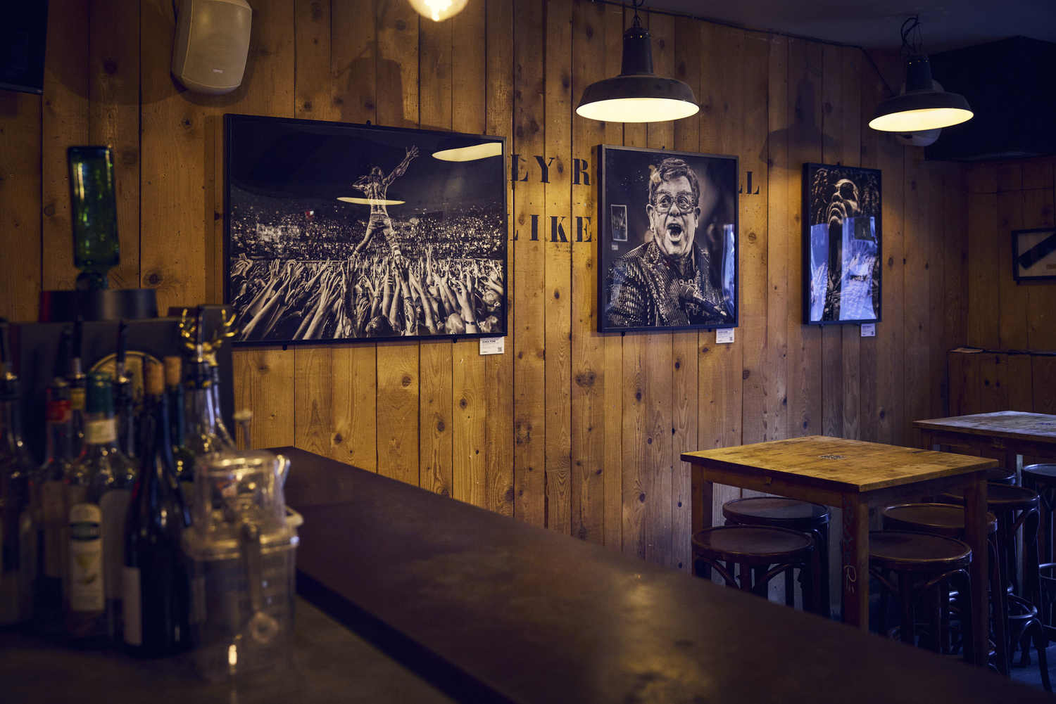 Vue d'ensemble de la salle de La Distillerie avec plusieurs tirages photo accrochés au mur, Montpellier
