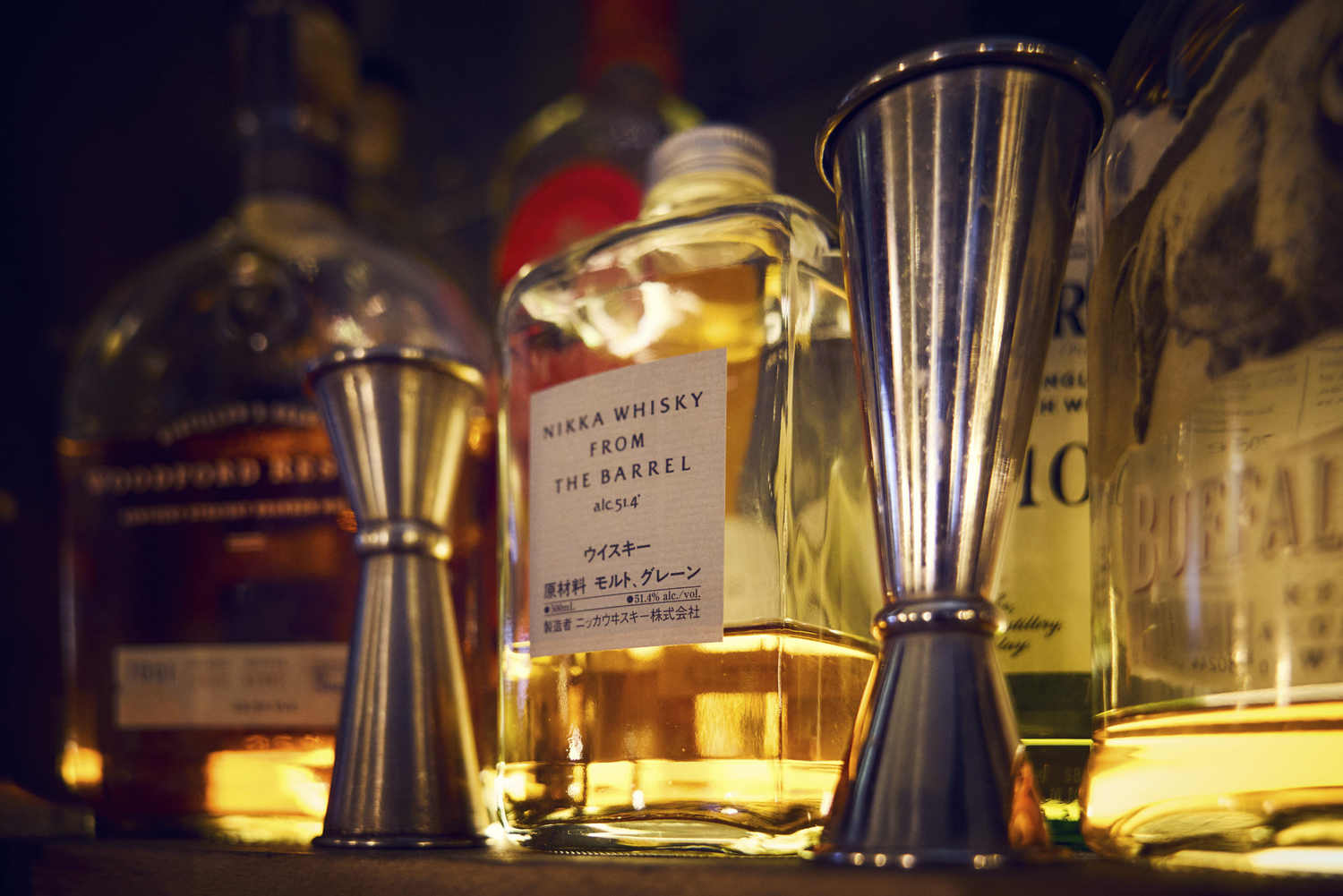 Verres doseurs et bouteille de whisky sur le comptoir de La Distillerie à Montpellier