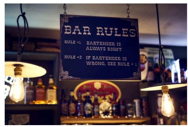 Pancarte humoristique Bar Rules au-dessus du comptoir de La Distillerie à Montpellier